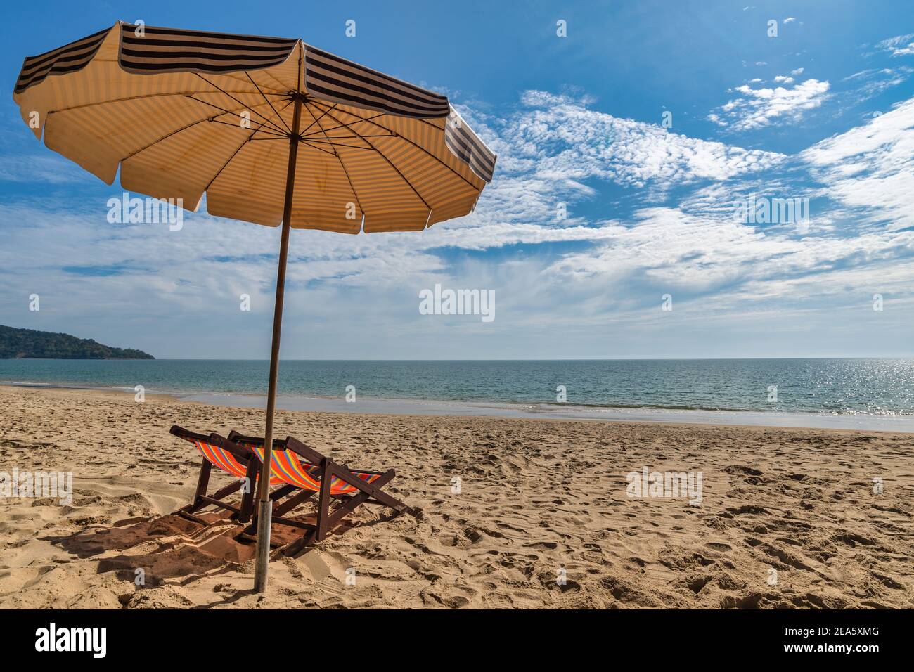Beach summer travel vacation concept with chair umbrella white sand beach blue sky and sea water ocean Stock Photo