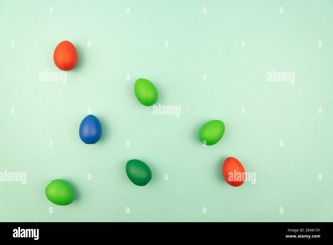 multicolored easter eggs on light blue background with copy space. Stock Photo