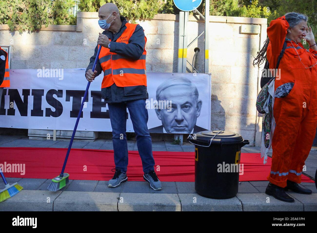 Jerusalem. 08th Feb, 2021. Activists dressing up as prisoners conduct a mock cleanup operation to 'clean up the streets from corruption' during a demonstration demanding the resignation of the Israeli Prime Minister Benjamin Netanyahu. Netanyahu was due to report on Monday to Jerusalem's District Court to formally respond to the indictment in the corruption trial against him. Credit: Ilia Yefimovich/dpa/Alamy Live News Stock Photo