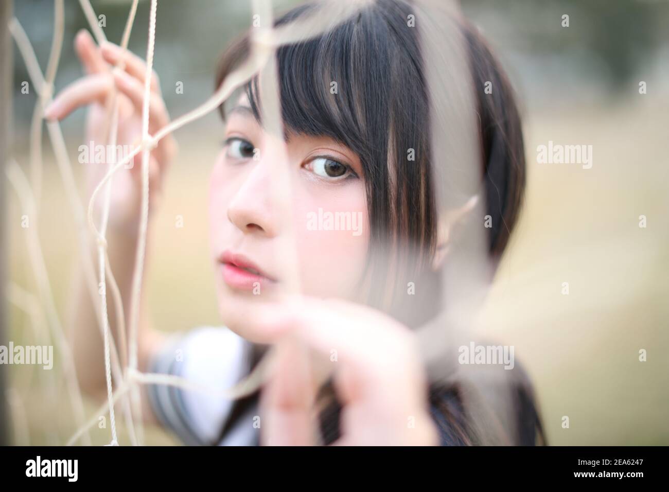 Portrait of beautiful Asian japanese high school girl uniform looking with net Stock Photo