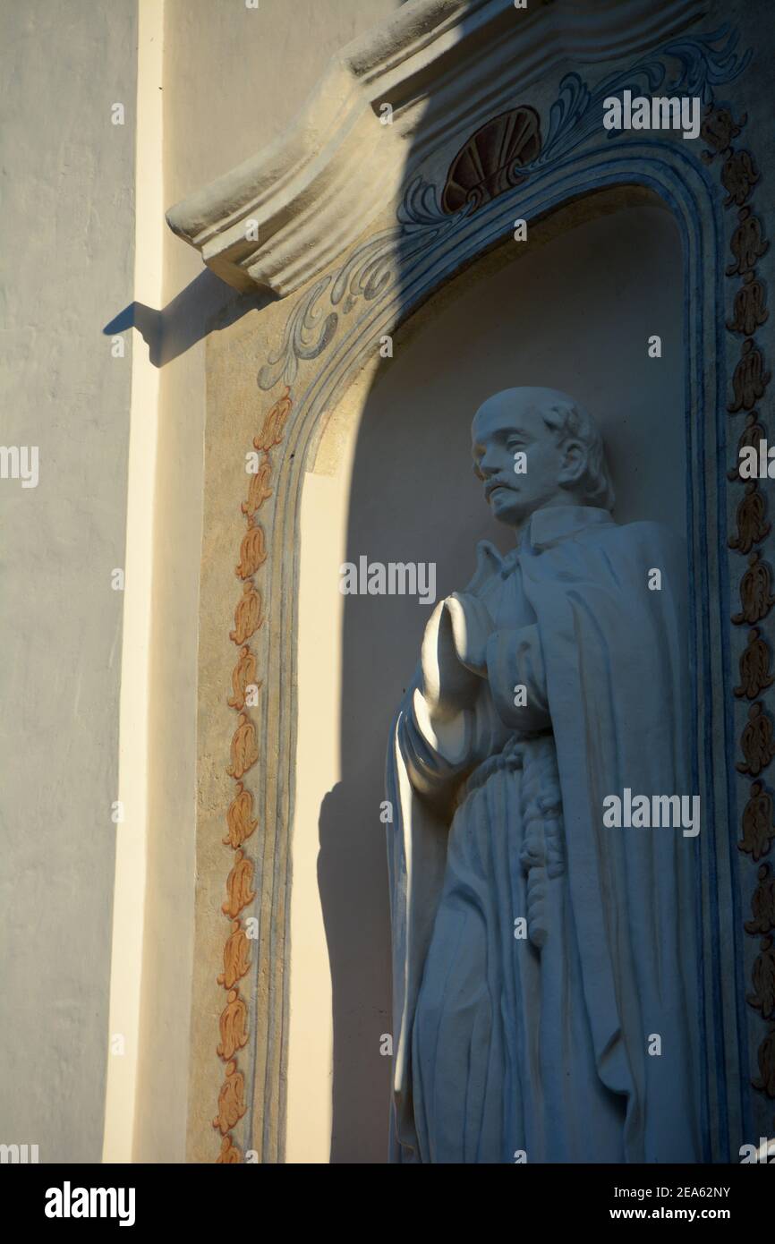 saint sculpture praying on historical church wall Stock Photo