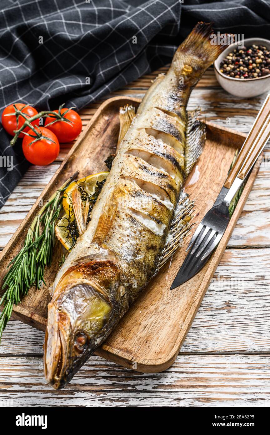 Grilled pike perch pikeperch fish. White wooden background. Top