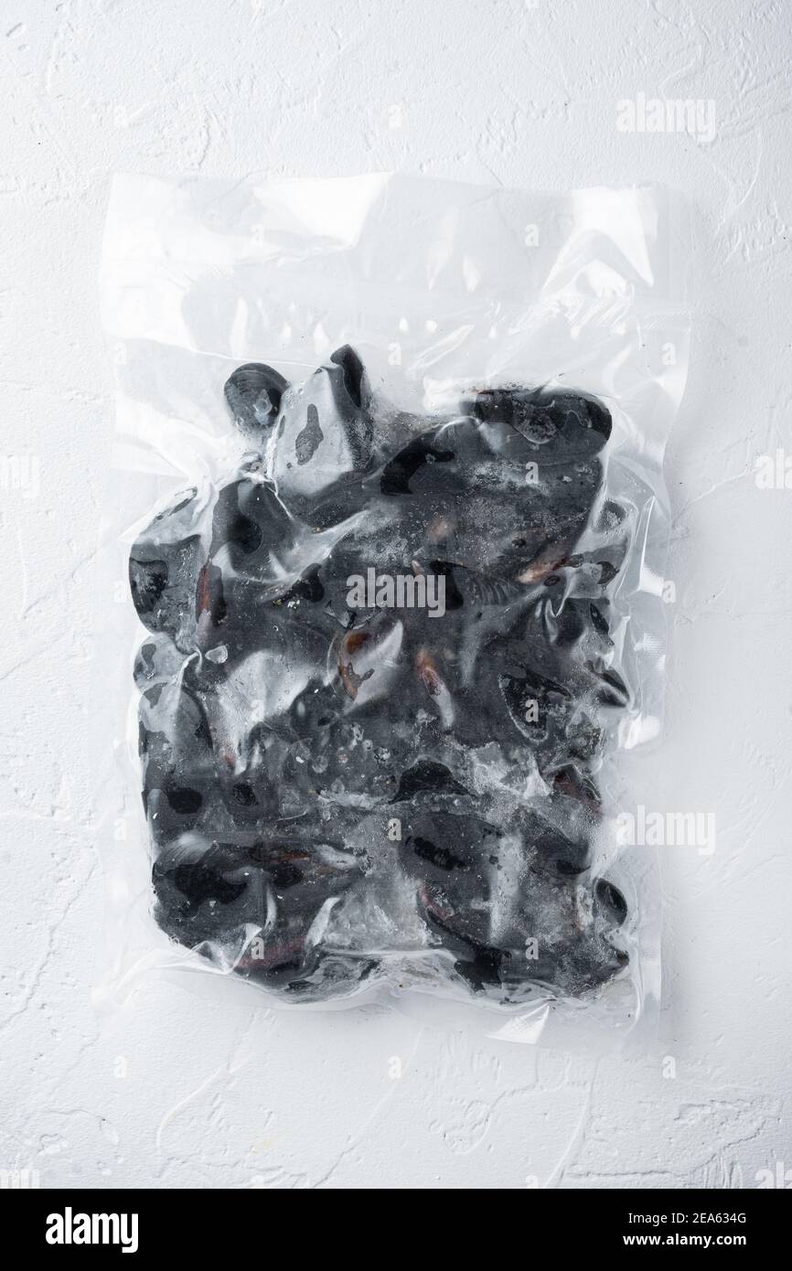 Vacuum packed whole shell mussels frozen, on white background, top view