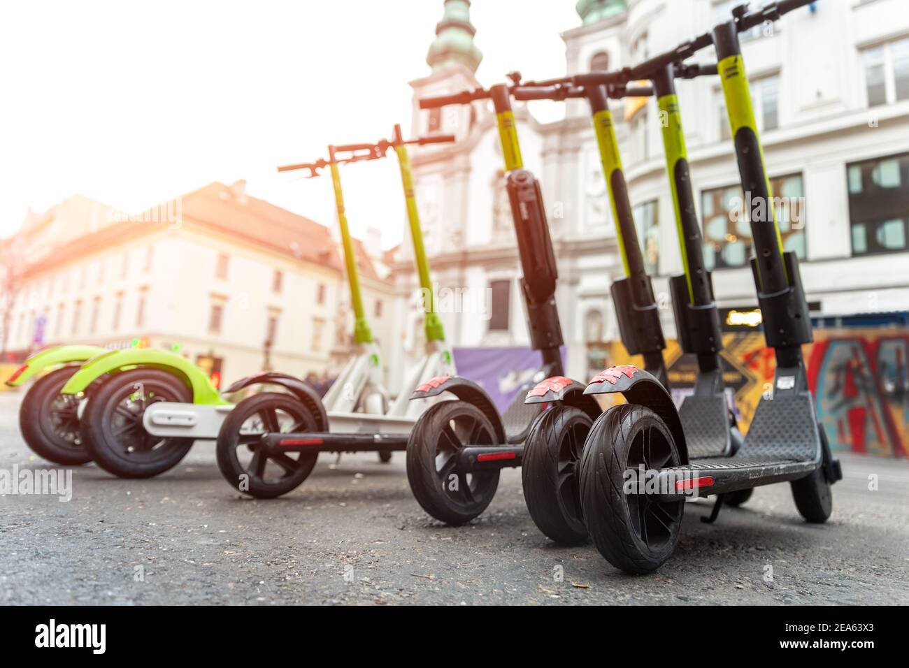 Many modern electric kick scooters sharing parked on city street. Self