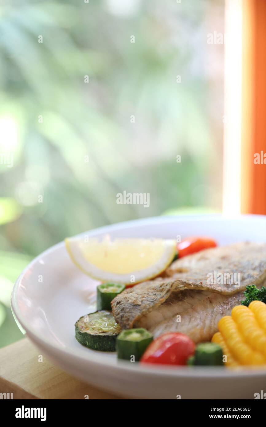 Sea bass fillet , baked sea bass with lemon sauce on wood background Stock Photo