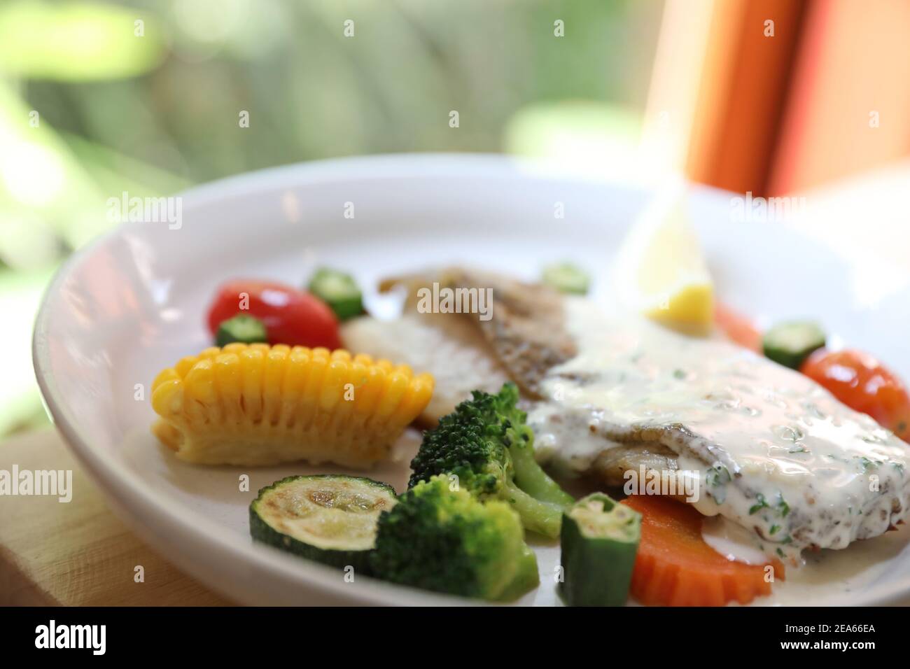 Sea bass fillet , baked sea bass with lemon sauce on wood background Stock Photo