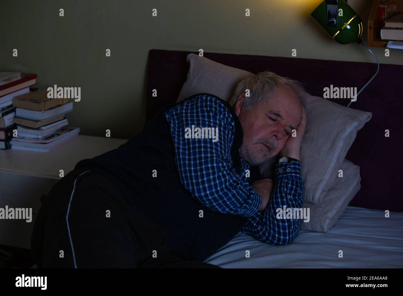 Senior man fell asleep during watching a TV or television at midnight