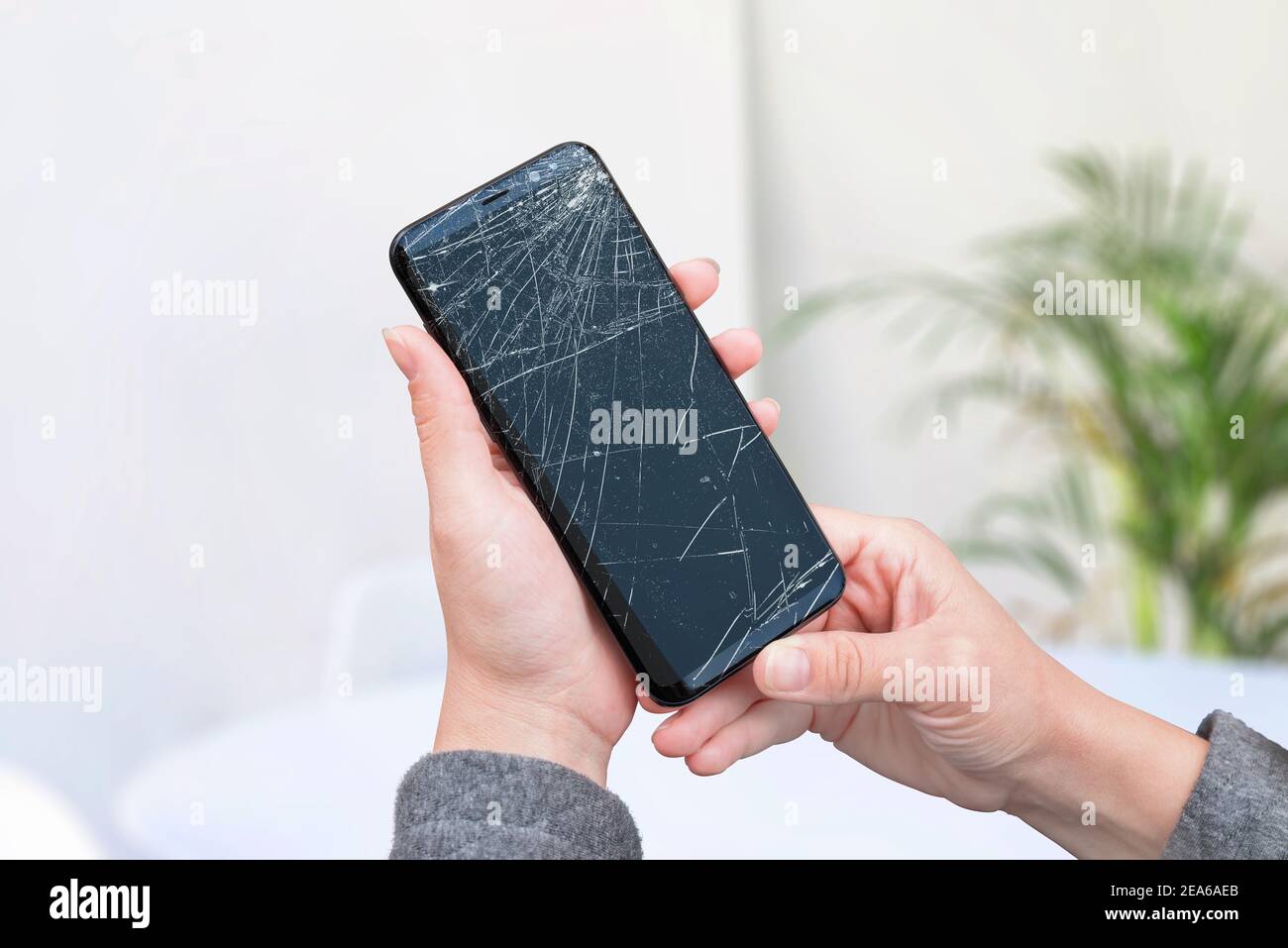 Broken phone in woman hands. Smashed display concept Stock Photo