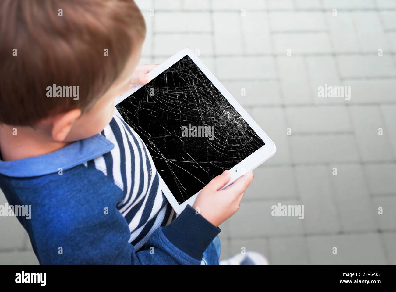 Broken tablet in boy hands concept. Smashed screen after drop Stock Photo