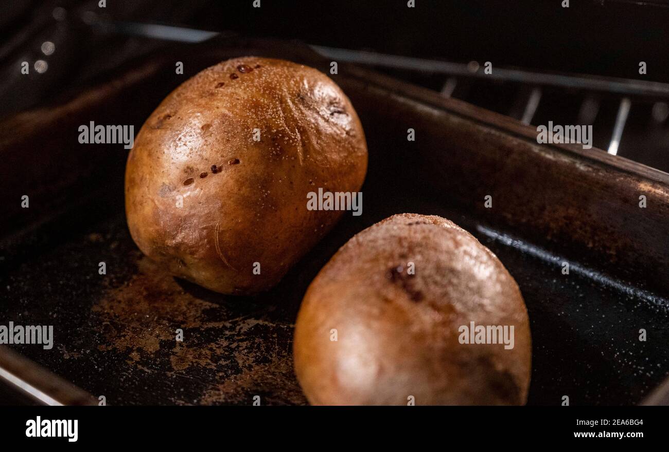 Baking potatoes in their skins or jackets in electric oven on a tray