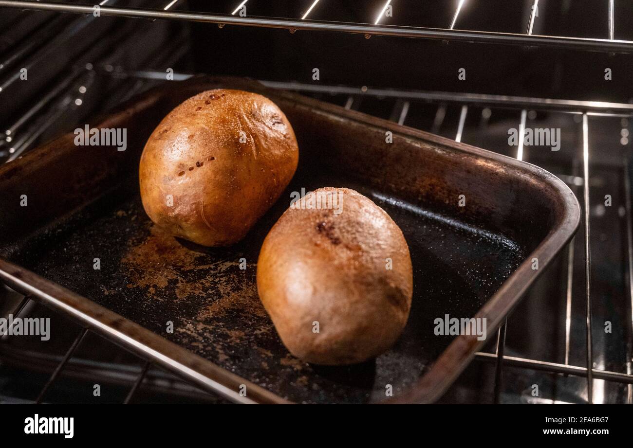 Baking potatoes in their skins or jackets in electric oven on a tray