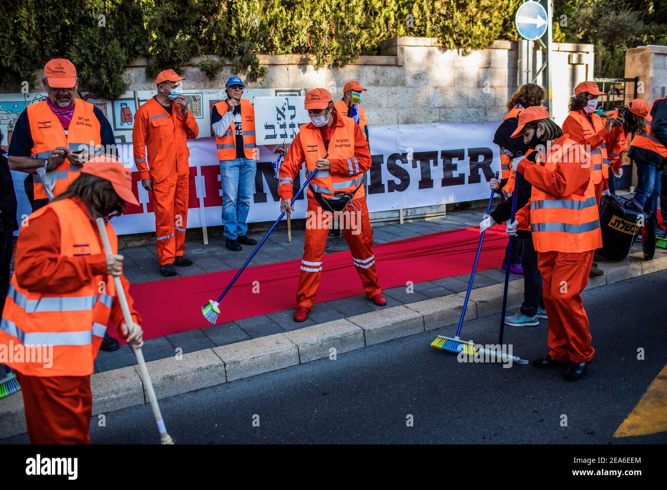 Jerusalem. 08th Feb, 2021. Activists dressing up as prisoners conduct a mock cleanup operation to 'clean up the streets from corruption' during a demonstration demanding the resignation of the Israeli Prime Minister Benjamin Netanyahu outside Jerusalem's District Court where he is responding the corruption charges against him. Credit: Ilia Yefimovich/dpa/Alamy Live News Stock Photo