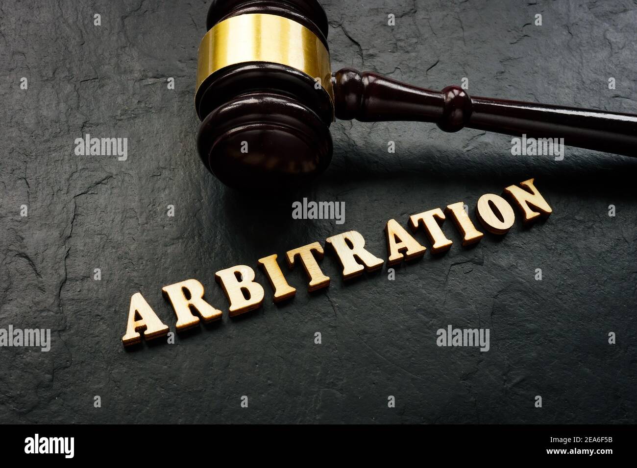 Arbitration word from wooden letters and gavel in court. Stock Photo