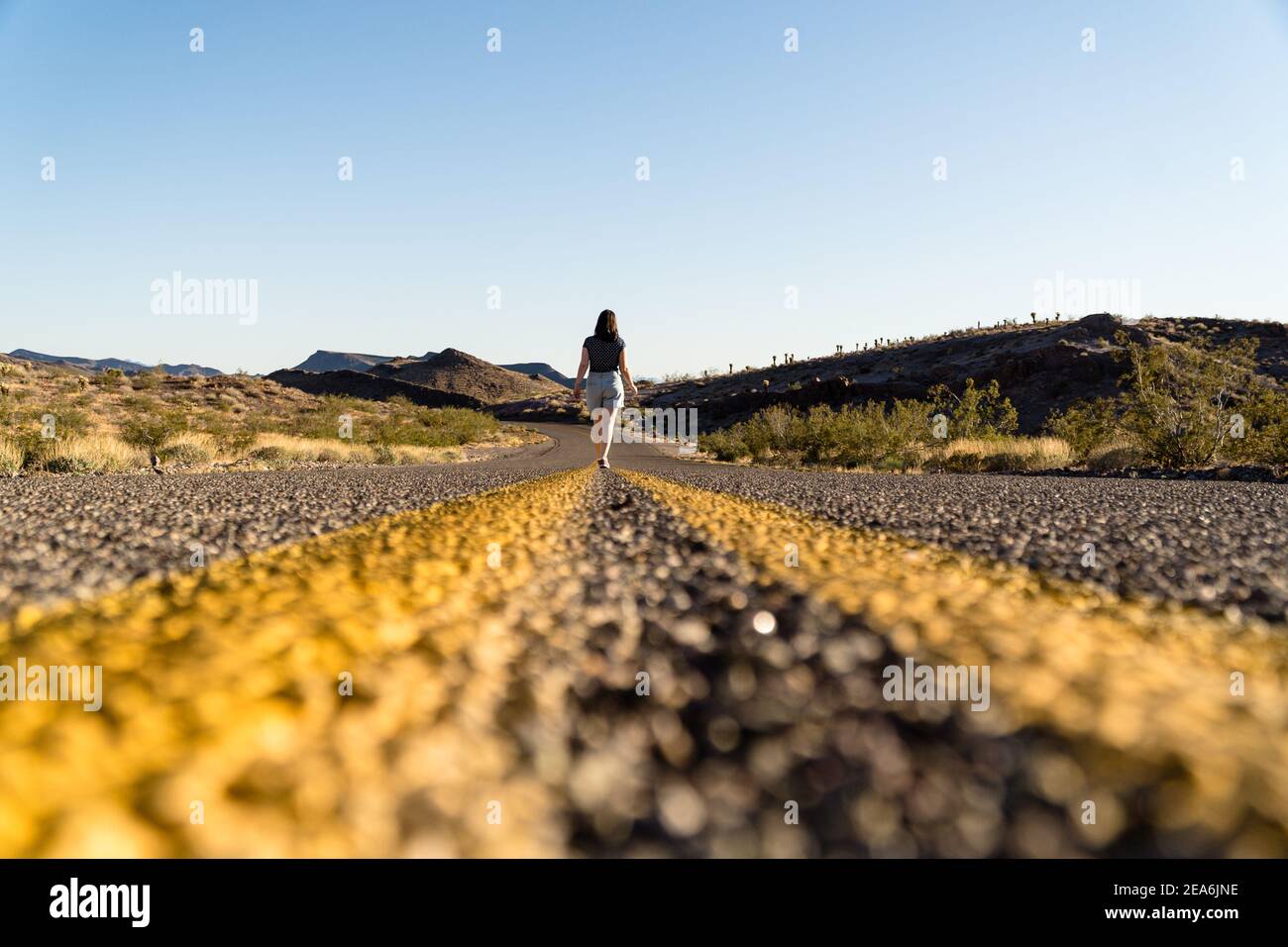 Back view of a female walking along the road, an exciting trip to Arizona by the Route 6 Stock Photo