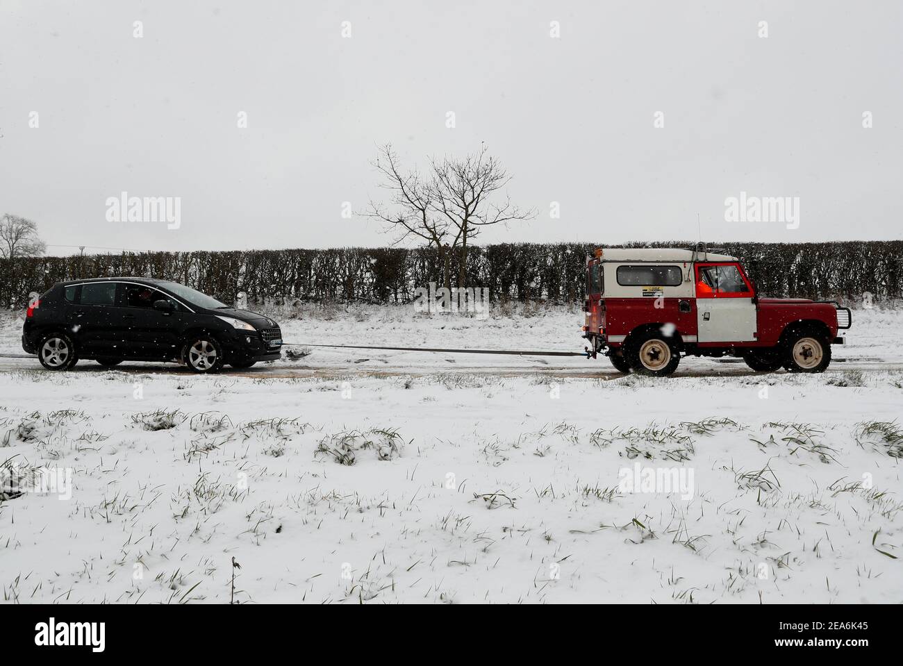 Uppingham, Rutland, UK. 8th February 2021. UK weather. A driver from Leicestershire and Rutland 4x4 Response pulls a stranded motorist up a snow and ice covered hill. Credit Darren Staples/Alamy Live News. Stock Photo