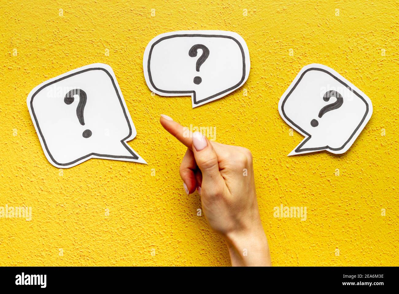 Question mark on speech bubbles with hand, top view. Solution concept Stock Photo