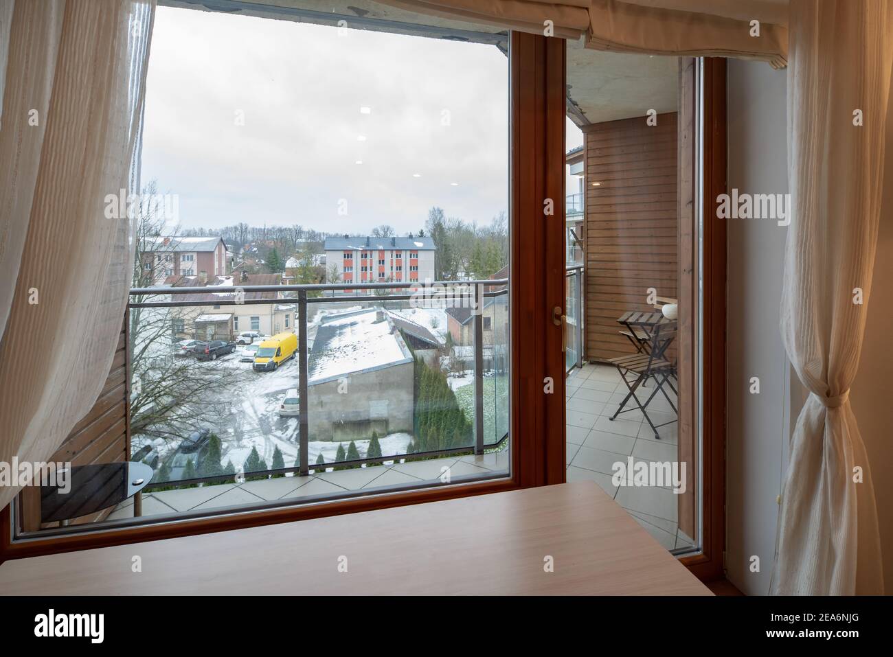 Modern interior of luxury apartment. Window and glass door to balcony. View of city. Stock Photo