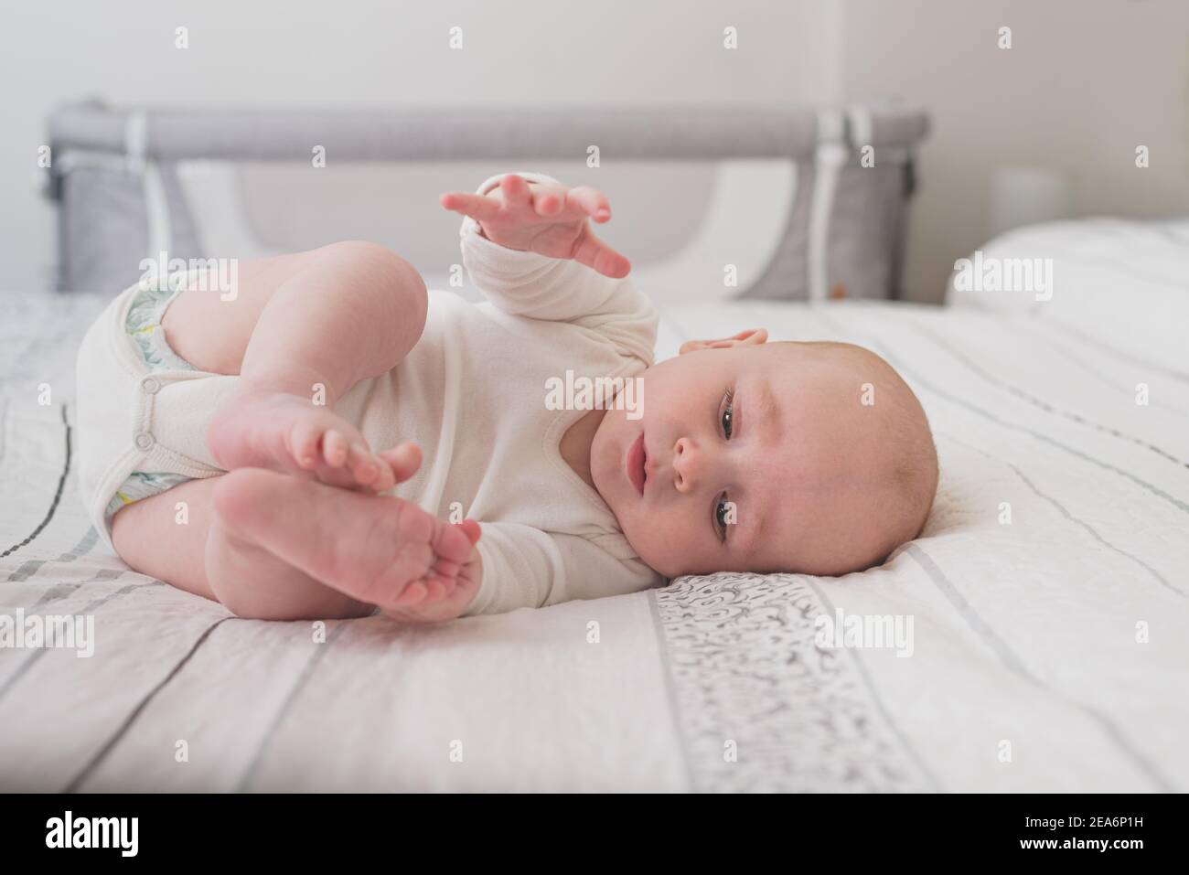 A cute baby sleeping on a huge bed with white sheets Stock Photo Alamy