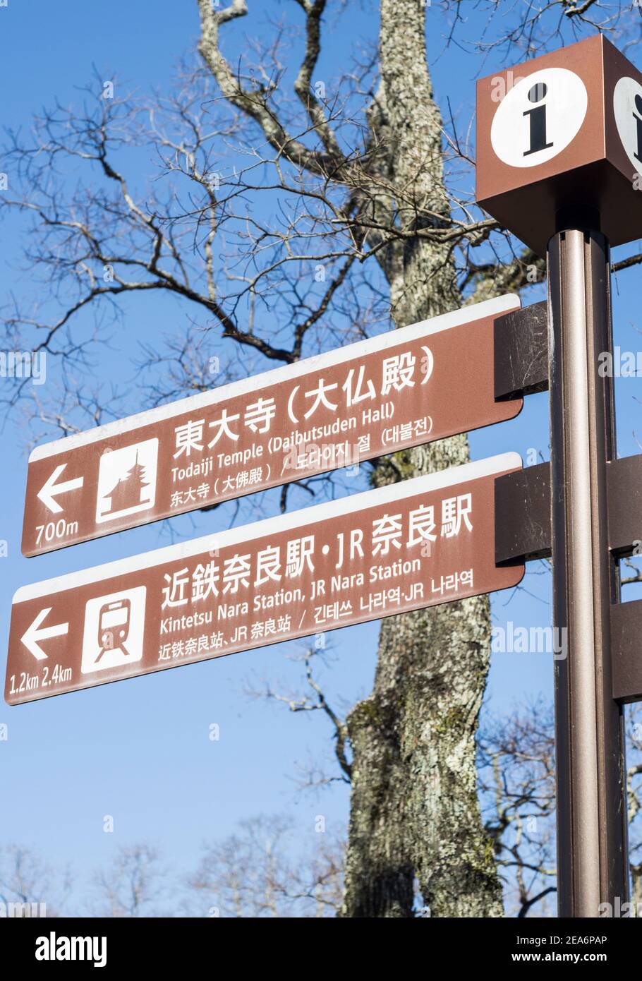 Brown direction sign posts to Todai-ji temple, and the Kintetsu and JR stations in Nara, Japan, on a sunny day Stock Photo