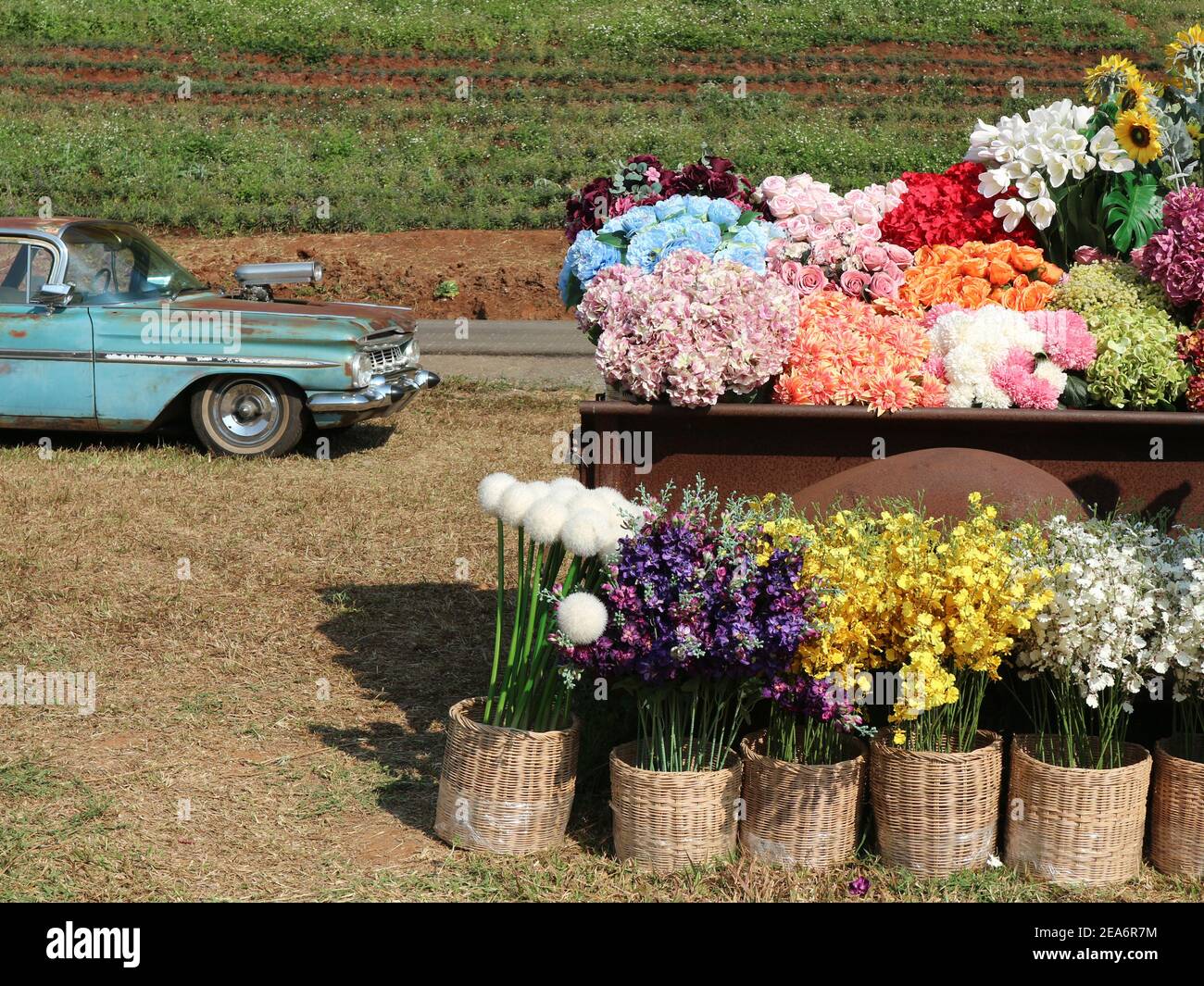 fake colorful flower in wicker basket decorating on vintage old retro
