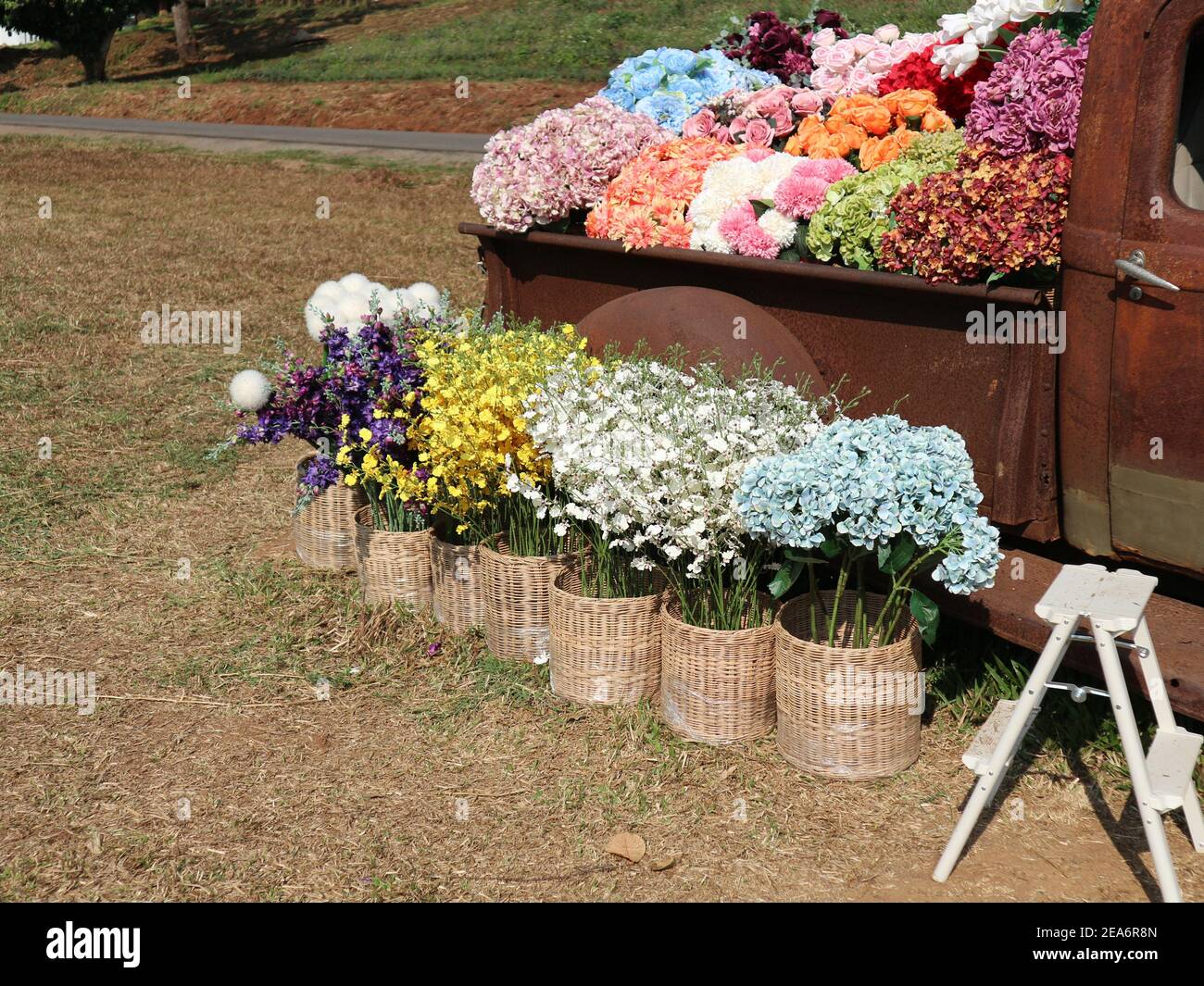 fake colorful flower in wicker basket decorating on vintage old retro
