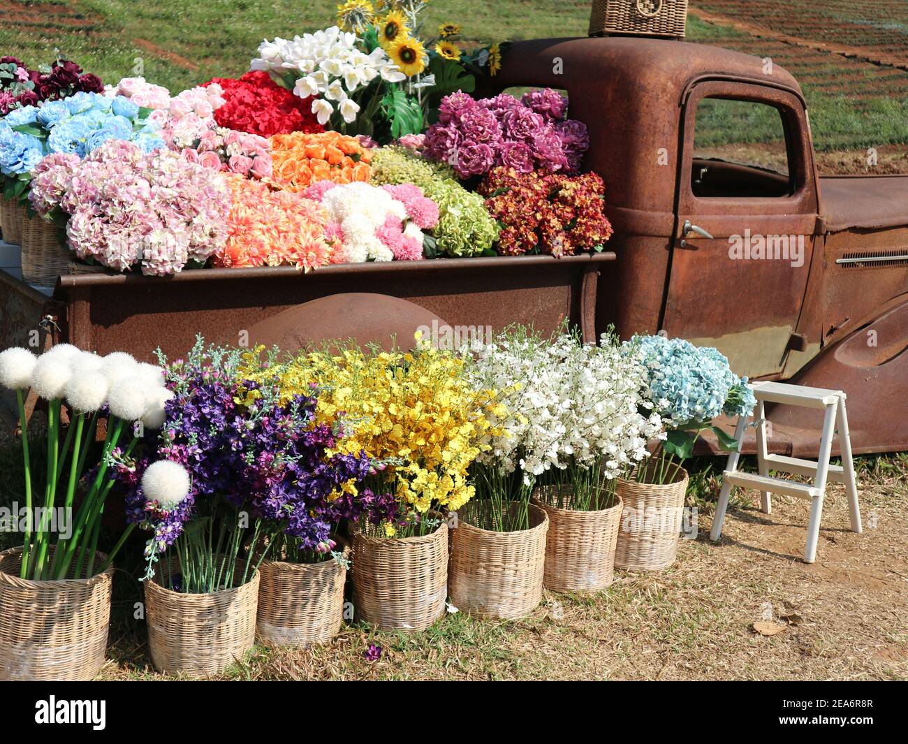 fake colorful flower in wicker basket decorating on vintage old retro