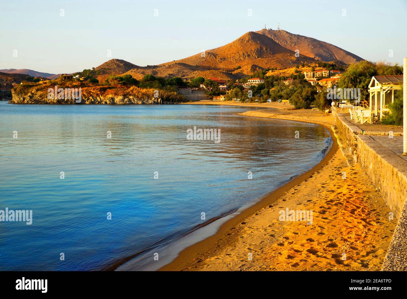 Mountain, calm beach and surrounding with houses of town Myrina, island Limnos, Greece in sunny autumn day. Stock Photo