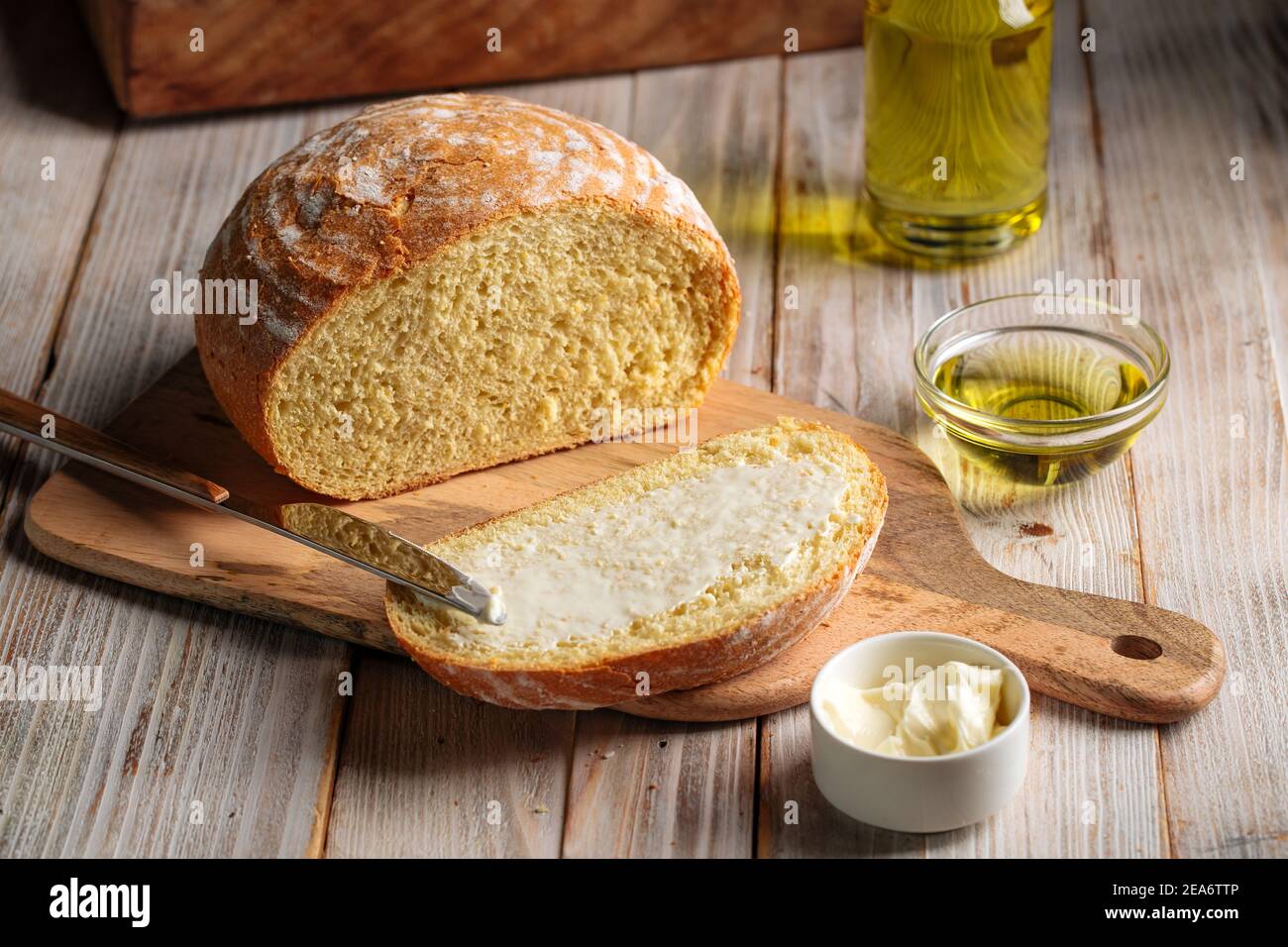 Cut loaf of olive oil bread spread with butter Stock Photo Alamy