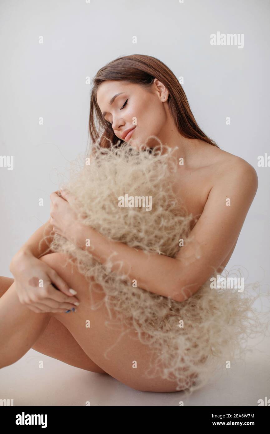 Naked woman protecting her modesty with a bouquet of dried plants Stock Photo