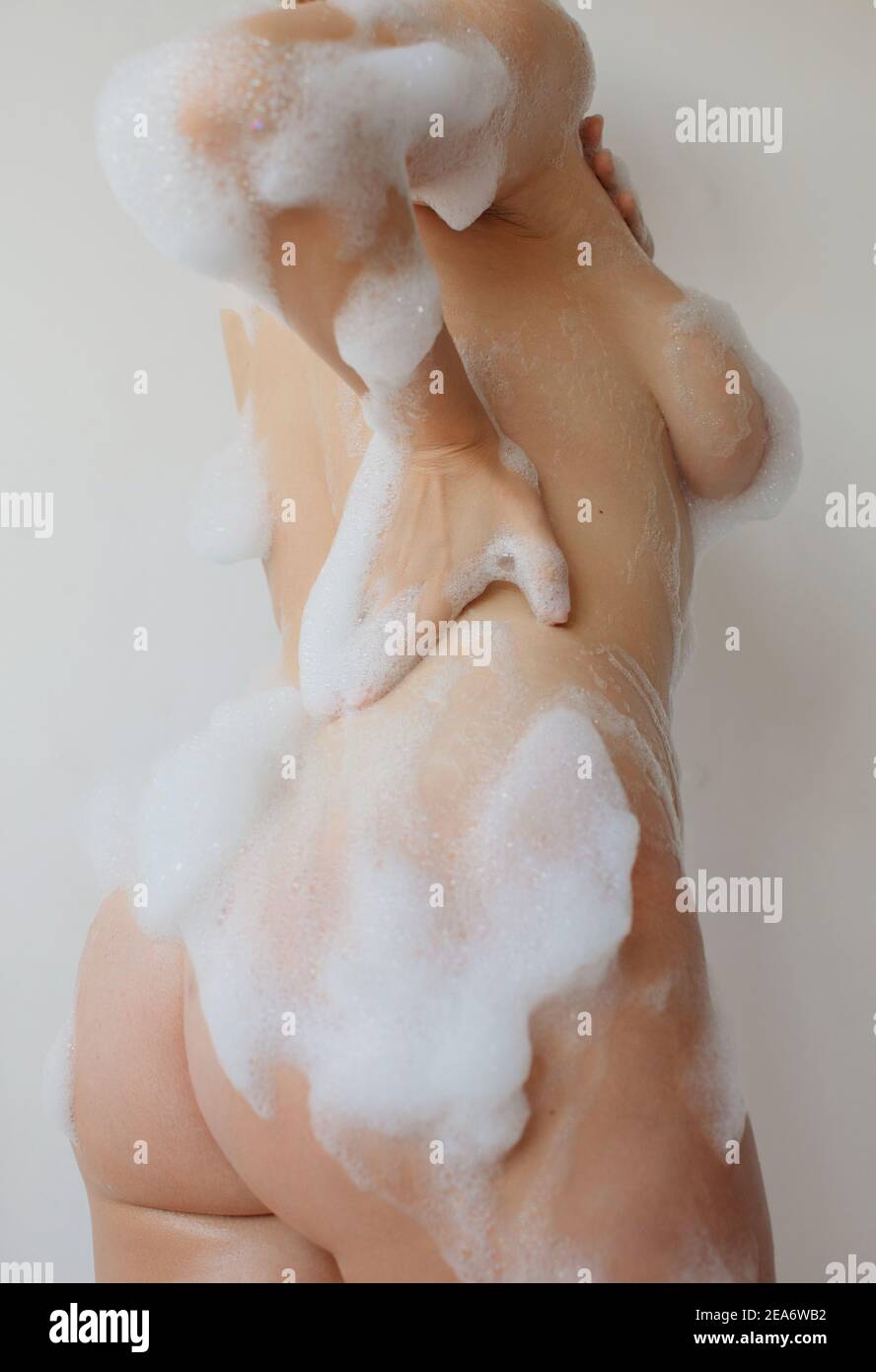 Rear view of a naked woman covered in soap suds Stock Photo