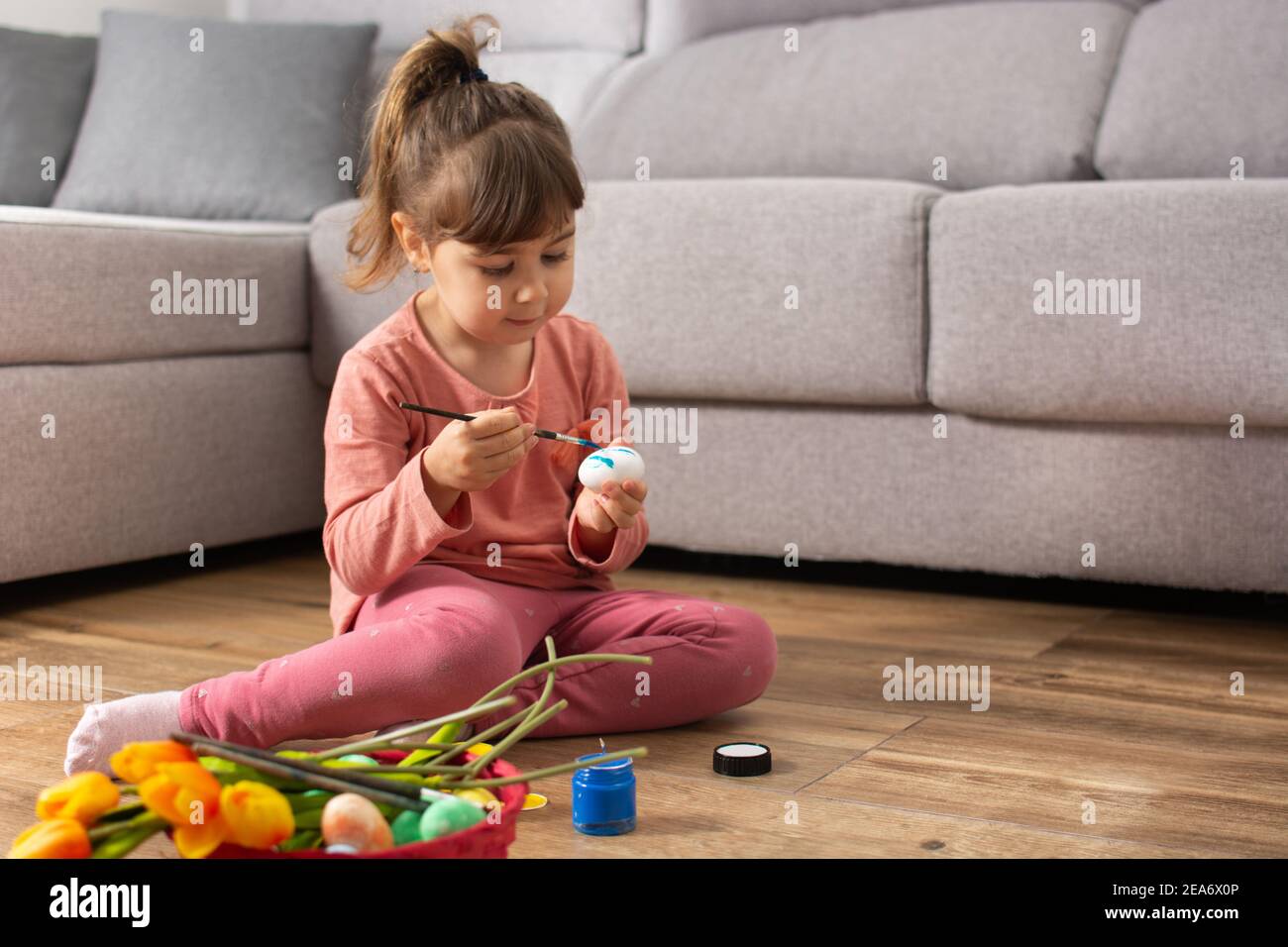 Baby gorl painting Easter eggs at home Stock Photo