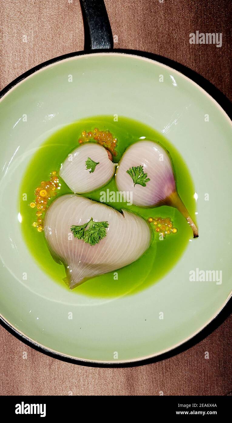 Onion in green cream sauce appetizer at michelin star restaurant in ljubljana slovenia Stock Photo
