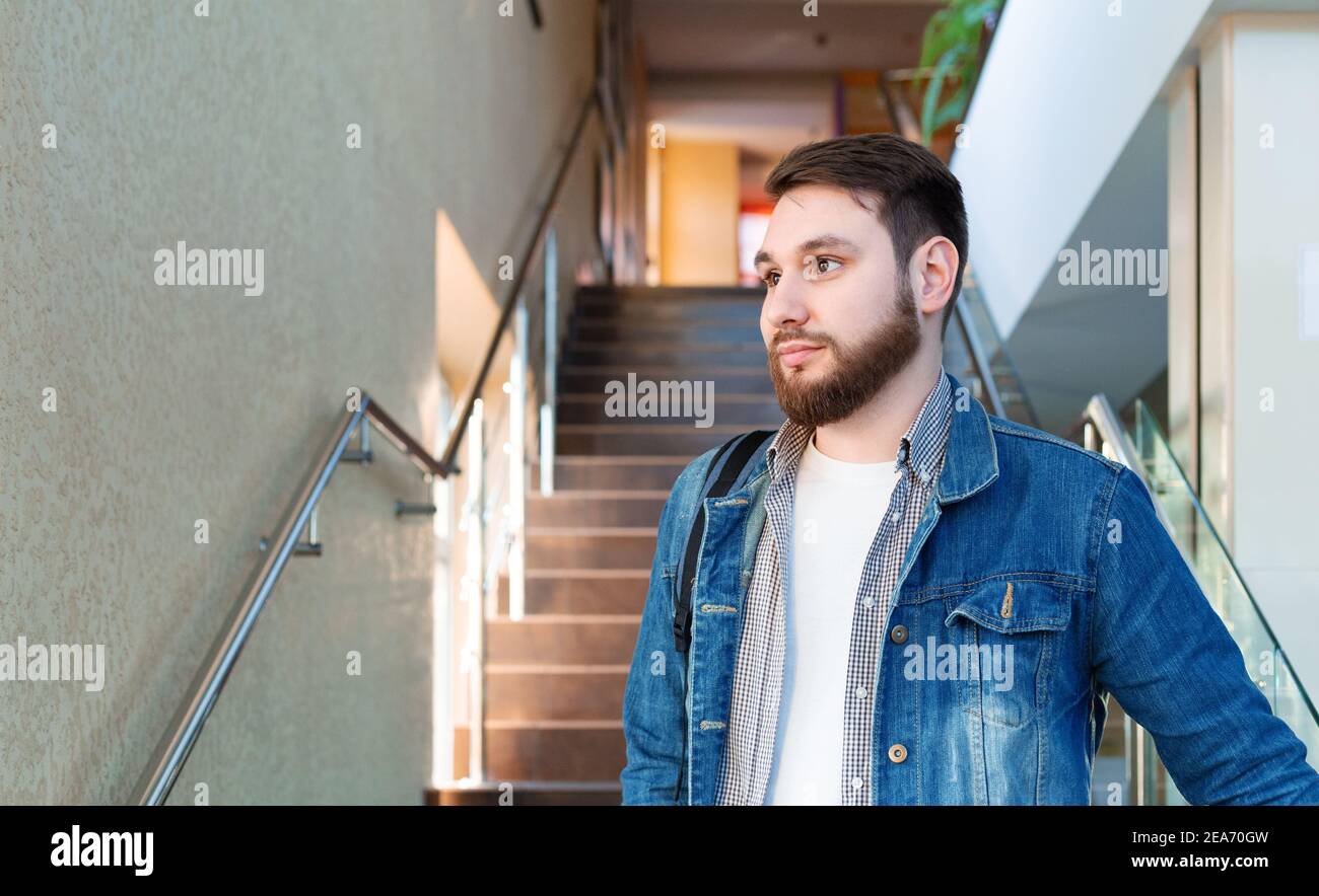 Portrait of caucasian young business man. Handsome bearded student on steps stairs. Copy space Stock Photo