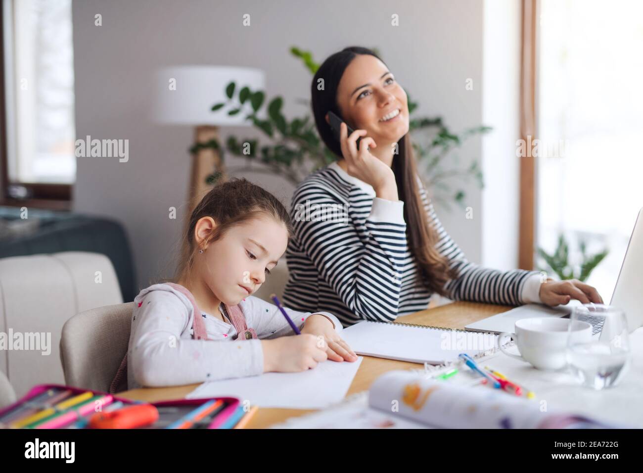 Mother with school girl indoors at home, distance learning and home ...