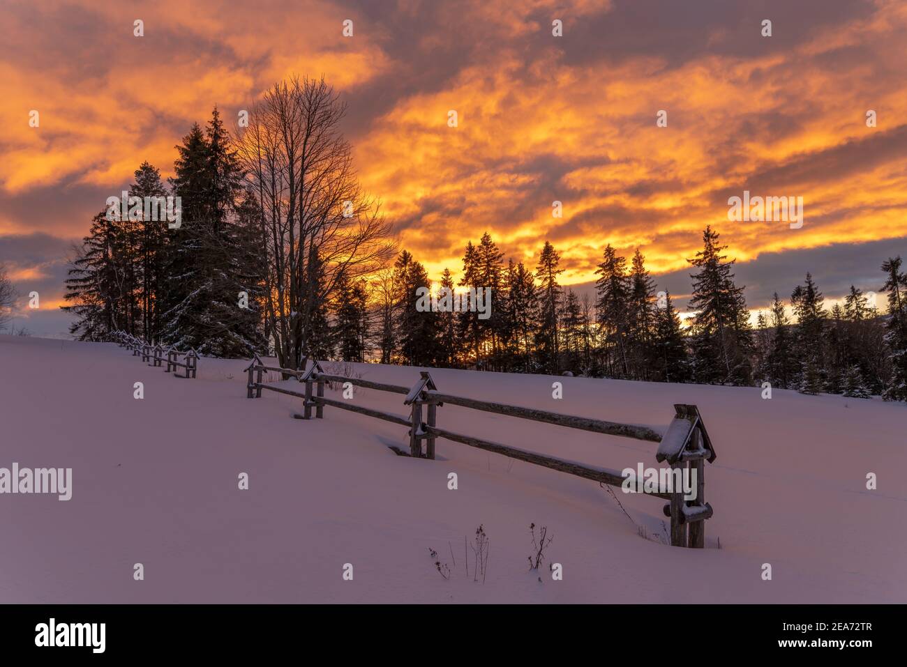 A fiery, dramatic sunrise in a winter mountain scenery Stock Photo