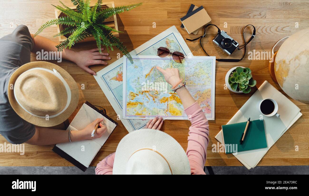 Top view of young couple with maps planning vacation trip holiday, desktop travel concept. Stock Photo