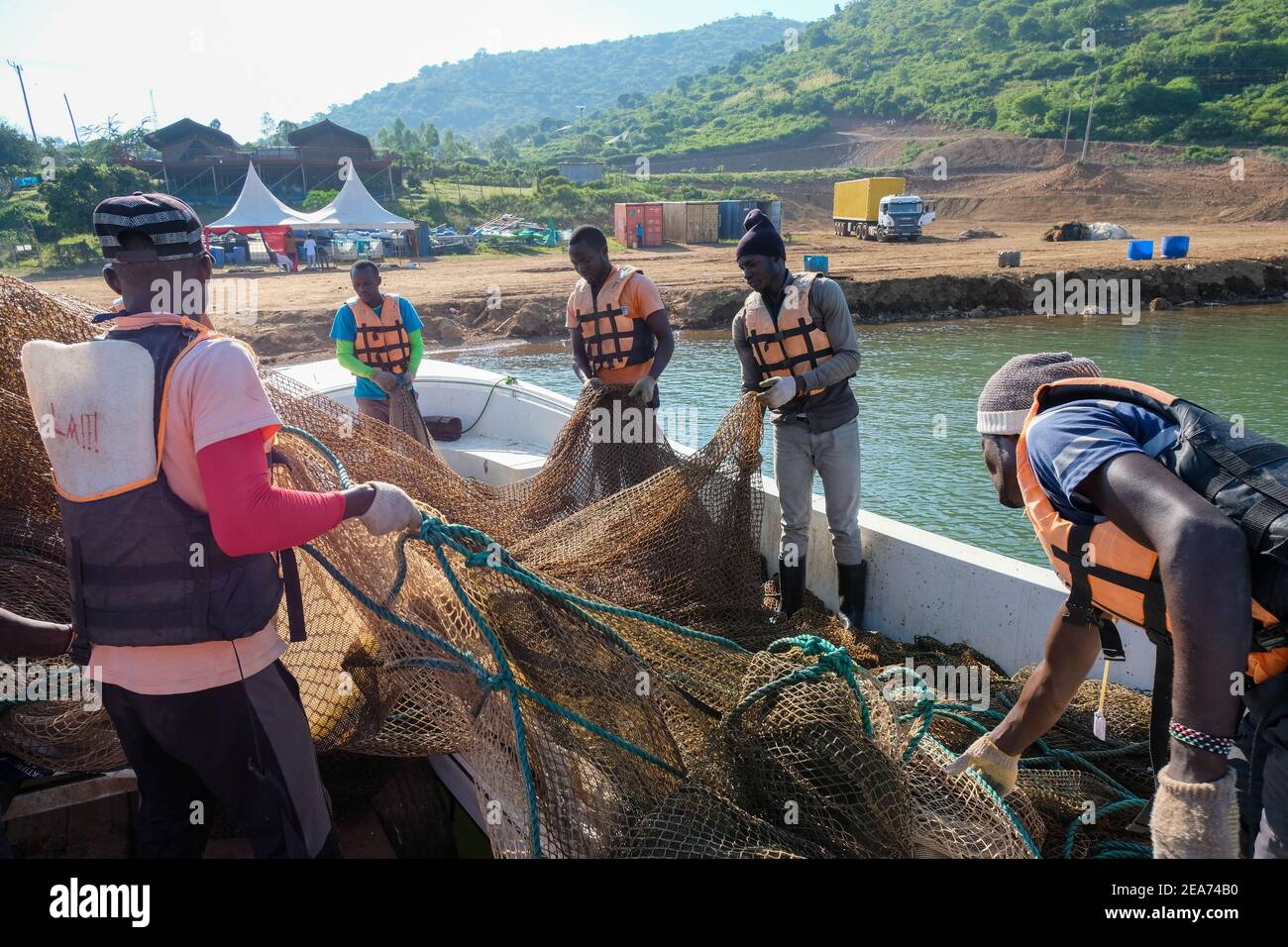 Employees of Victory Farms, the largest fish farmer in Kenya, fix netting  for a fish cage in Lake Victoria Stock Photo - Alamy