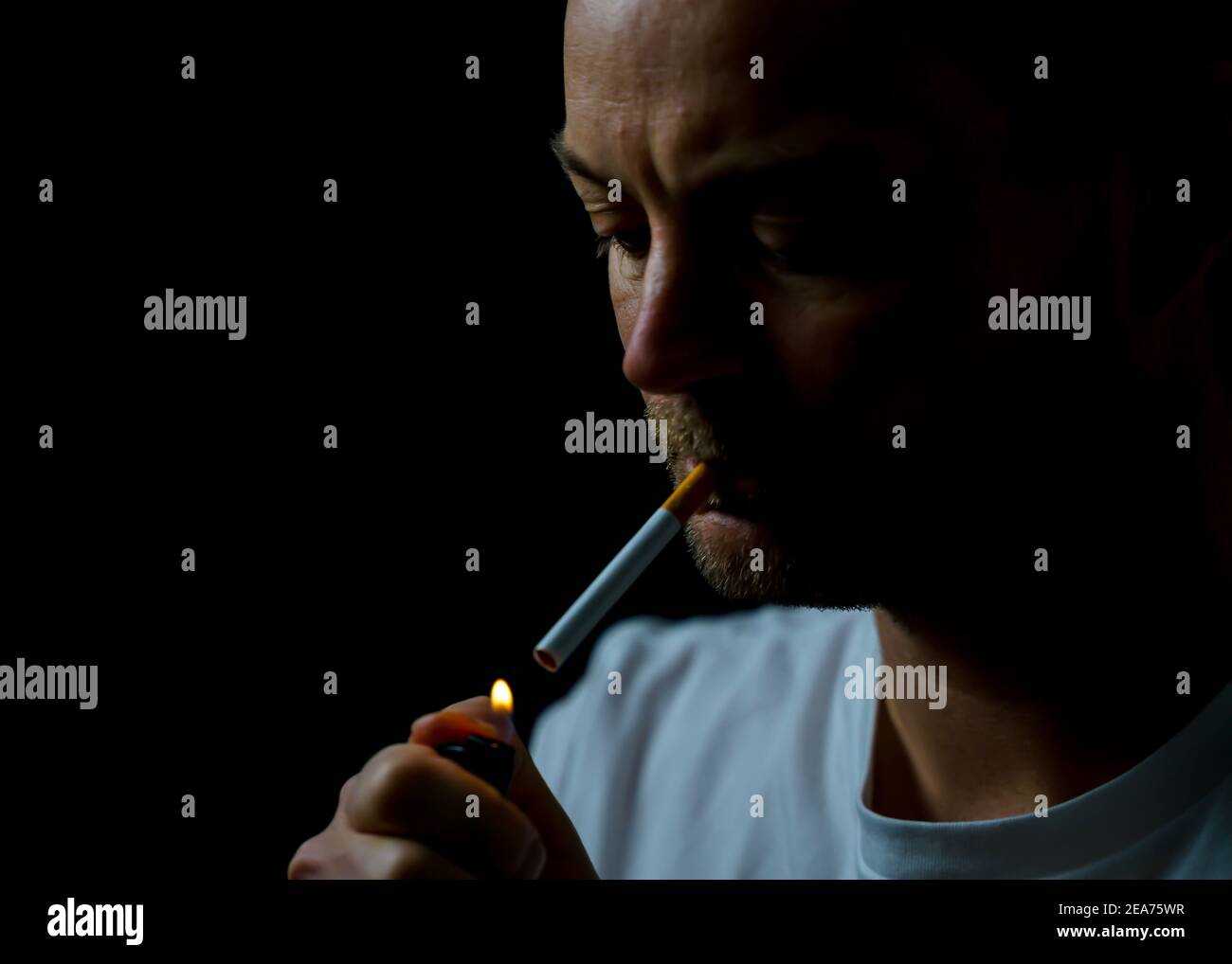 Man lighting a cigarette in a low light environment Stock Photo Alamy