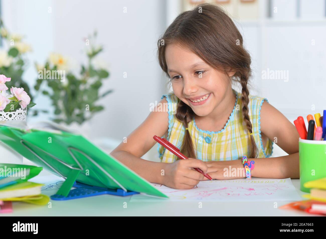 Portrait of cute little girl studying at home Stock Photo - Alamy