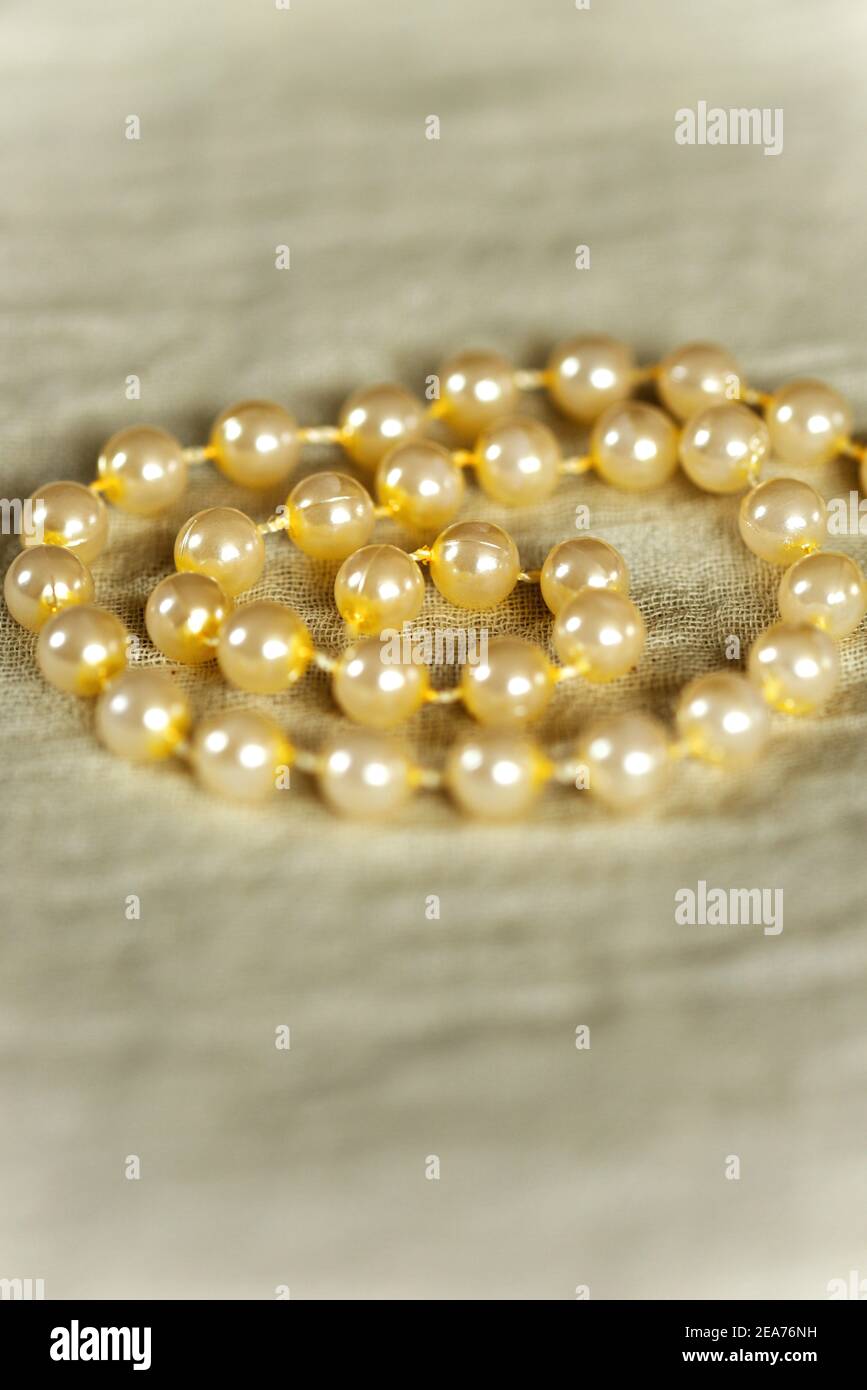String of pearls in a spiral on a muslin cloth Stock Photo