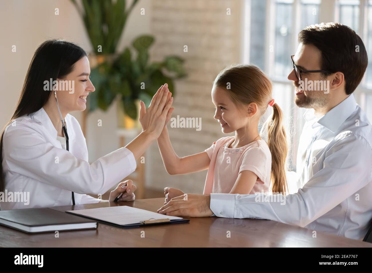 Happy female doctor cheer little child patient Stock Photo