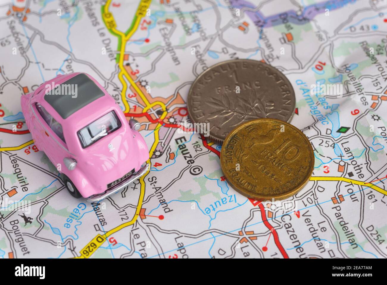 Toy 1950's pink BMW Isetta bubble car and French Franc coins on map of France showing part of the Armagnac producing region Stock Photo