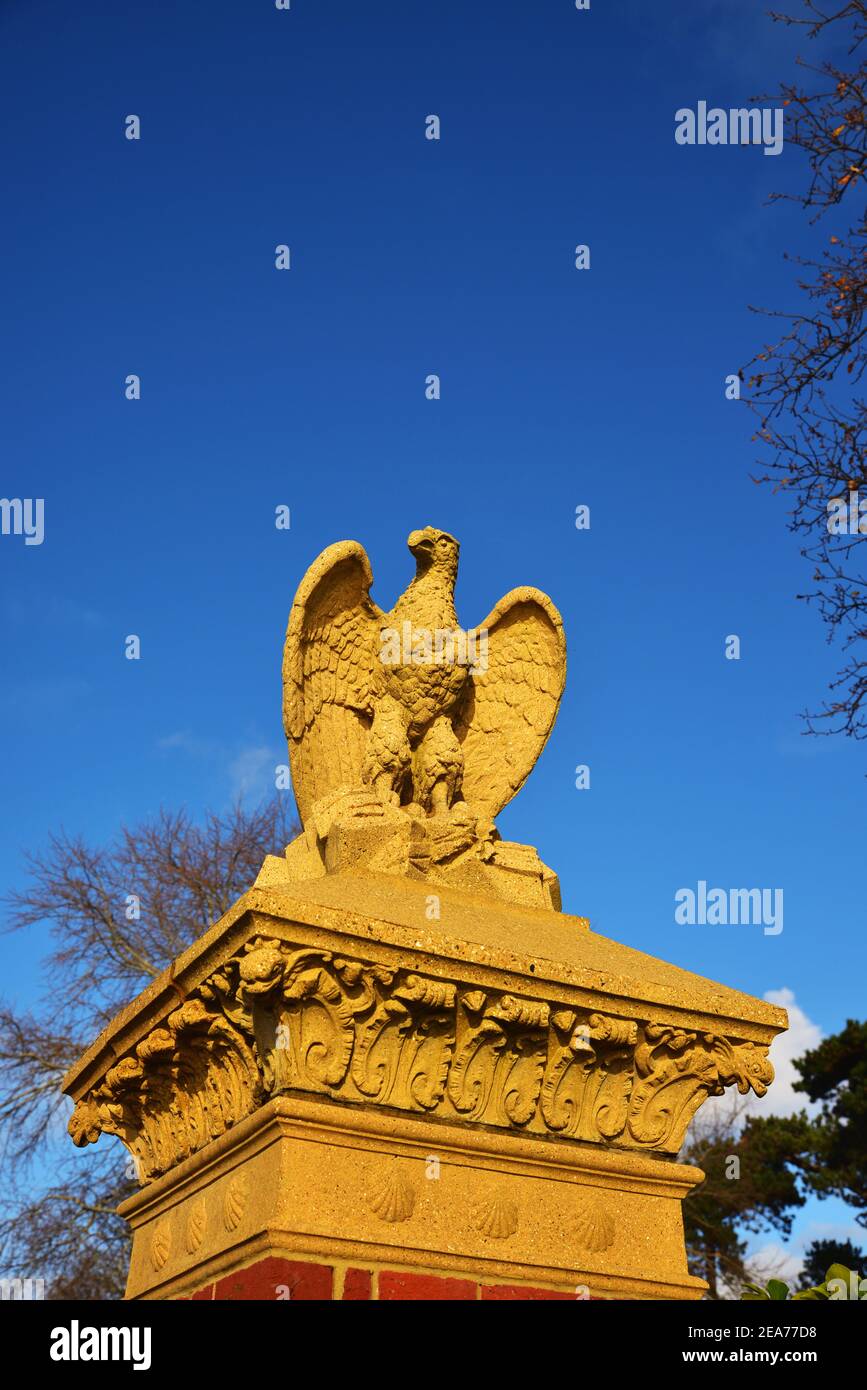 Stone eagle on top of a brick pillar against a blue sky, at the entranceto Poole Park, Dorset Stock Photo