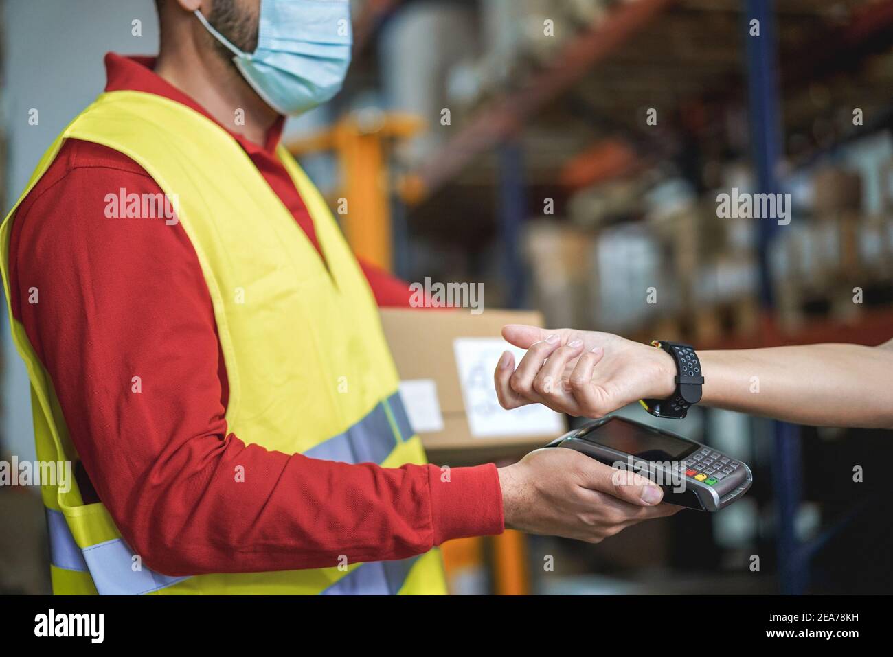 Young man making contactless payment inside warehouse store during ...