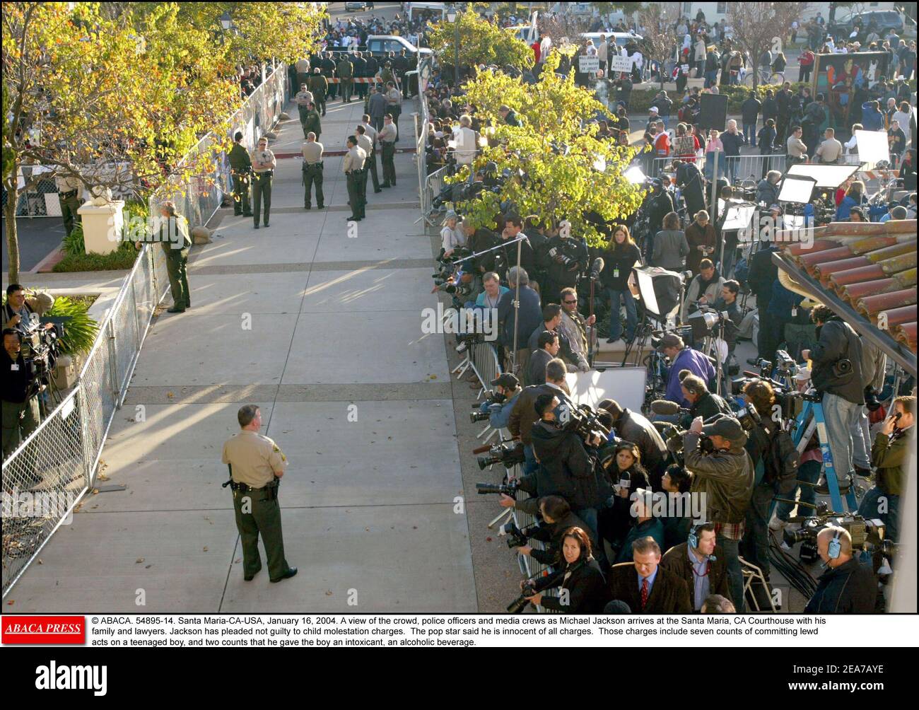 © ABACA. 54895-14. Santa Maria-CA-USA, January 16, 2004. A view of the crowd, police officers and media crews as Michael Jackson arrives at the Santa Maria, CA Courthouse with his family and lawyers. Jackson has pleaded not guilty to child molestation charges. The pop star said he is innocent of all charges. Those charges include seven counts of committing lewd acts on a teenaged boy, and two counts that he gave the boy an intoxicant, an alcoholic beverage. Stock Photo