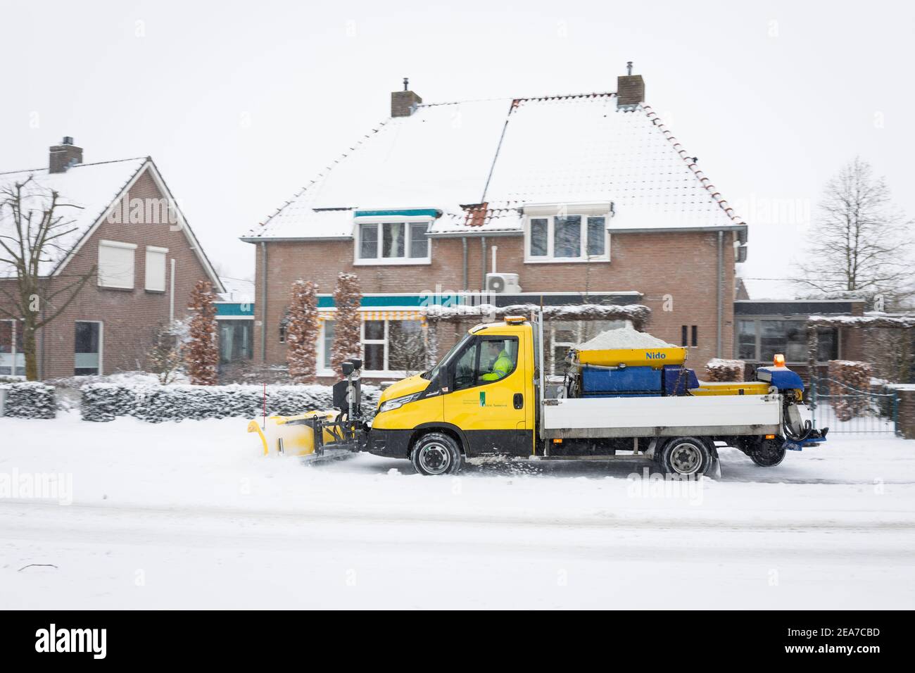 Snow shovel truck deicing a road while spreading salt in the