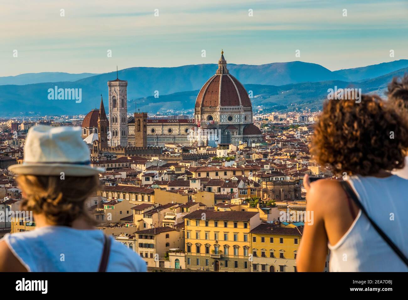 Two women admiring the panoramic view from the square Piazzale Michelangelo to the historic heart of Florence with the Cathedral Santa Maria del Fiore... Stock Photo