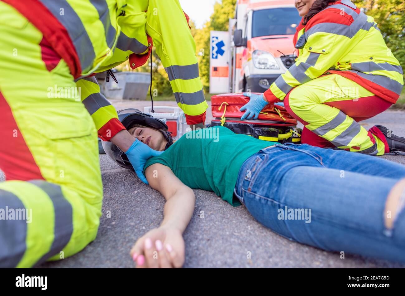 Paramedics removing helmet of injured motorcyclist after an accident