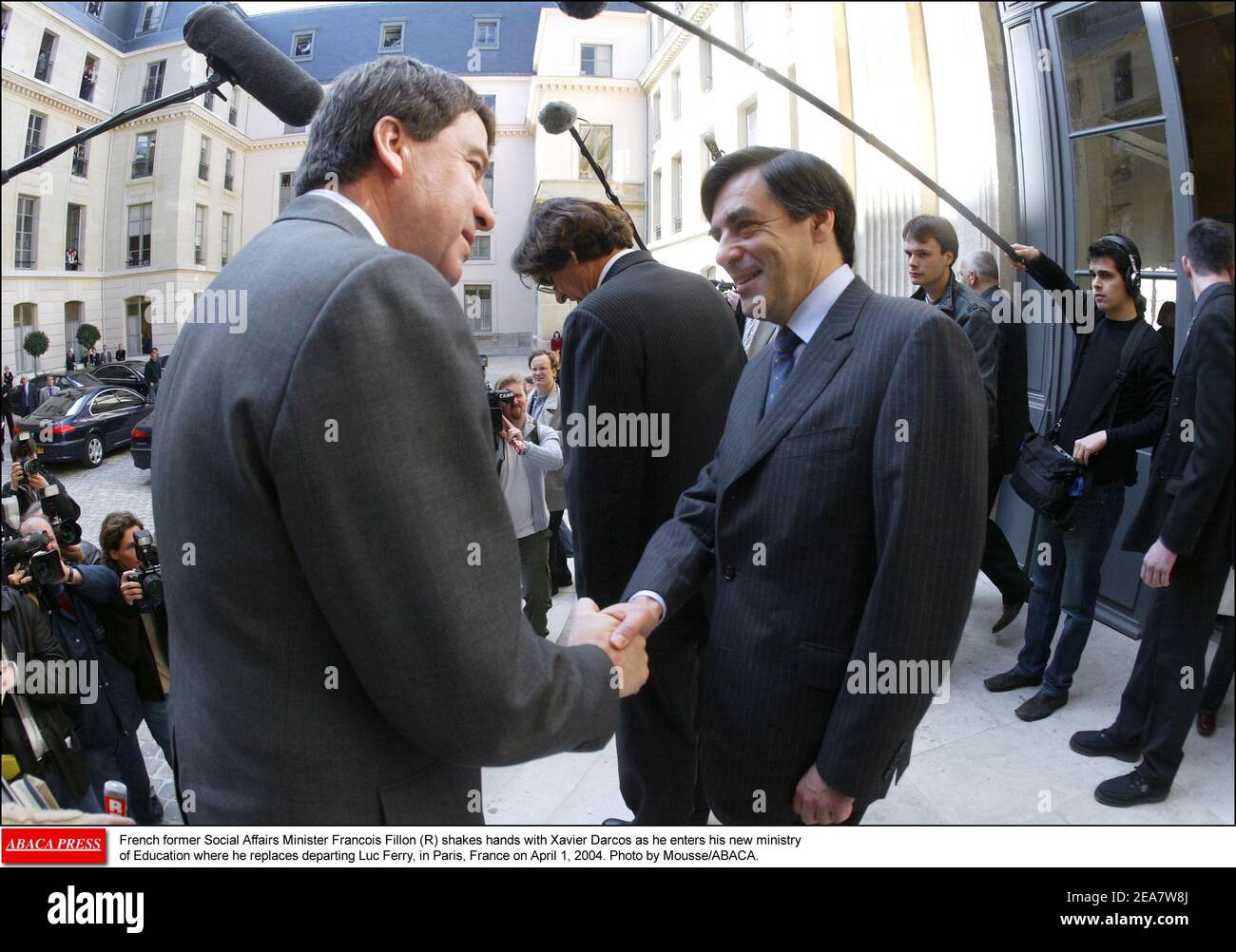 French former Social Affairs Minister Francois Fillon (R) shakes hands with Xavier Darcos as he enters his new ministry of Education where he replaces departing Luc Ferry, in Paris, France on April 1, 2004. Photo by Mousse/ABACA. Stock Photo