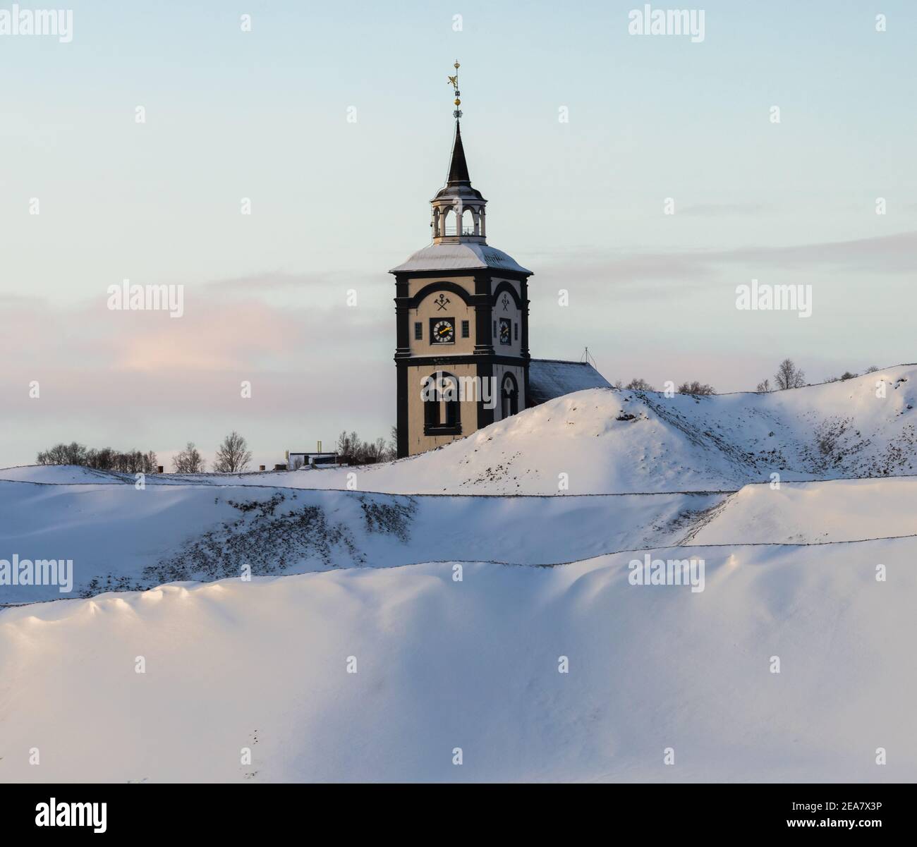 Røros church and its characteristic clock tower. Snowy wintertime in old, historical mining town. Norwegian historical place listed by UNESCO. Stock Photo